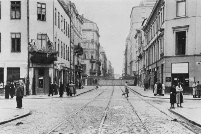 Street scene in the Warsaw ghetto showing a section of the wall blocking a major thoroughfare. Copyright United States Holocaust Memorial Museum.